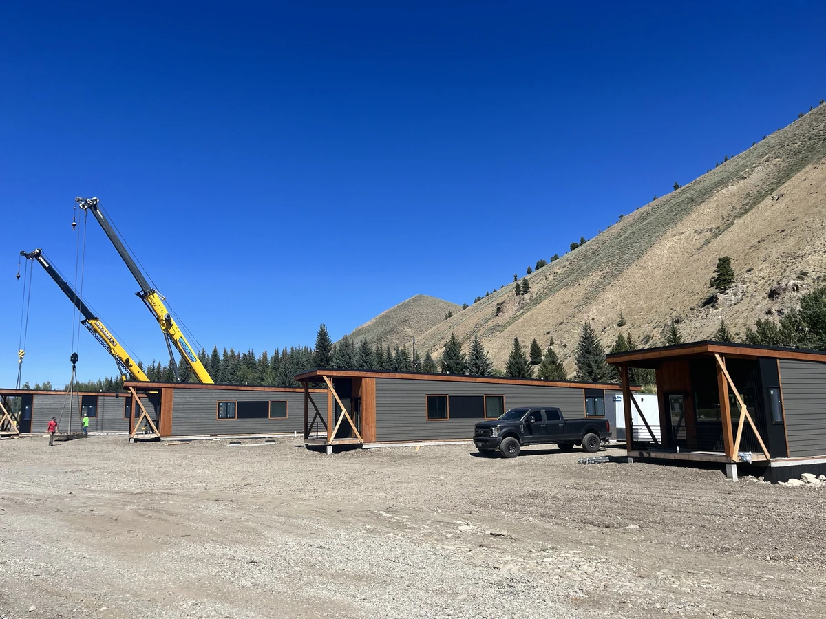 Row of single-story Ridgeline homes being set by crane for firefighter housing in Sun Valley, Idaho