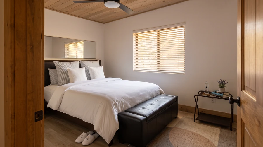 Bedroom with a bench and wood door in a modular rental at Island Park, Idaho