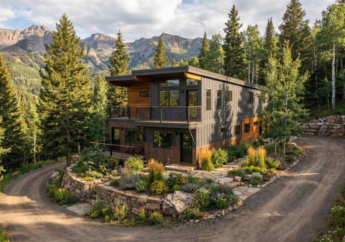 Contemporary mountain home surrounded by lush trees and mountain scenery.