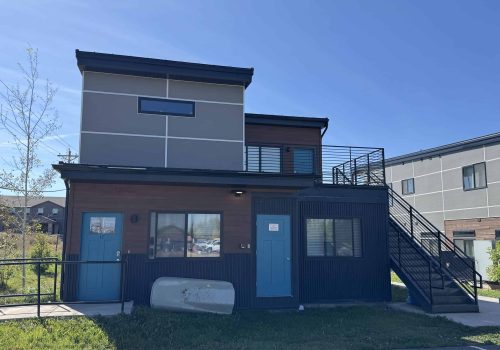 Modern modular tiny home with sleek design and outdoor staircase.