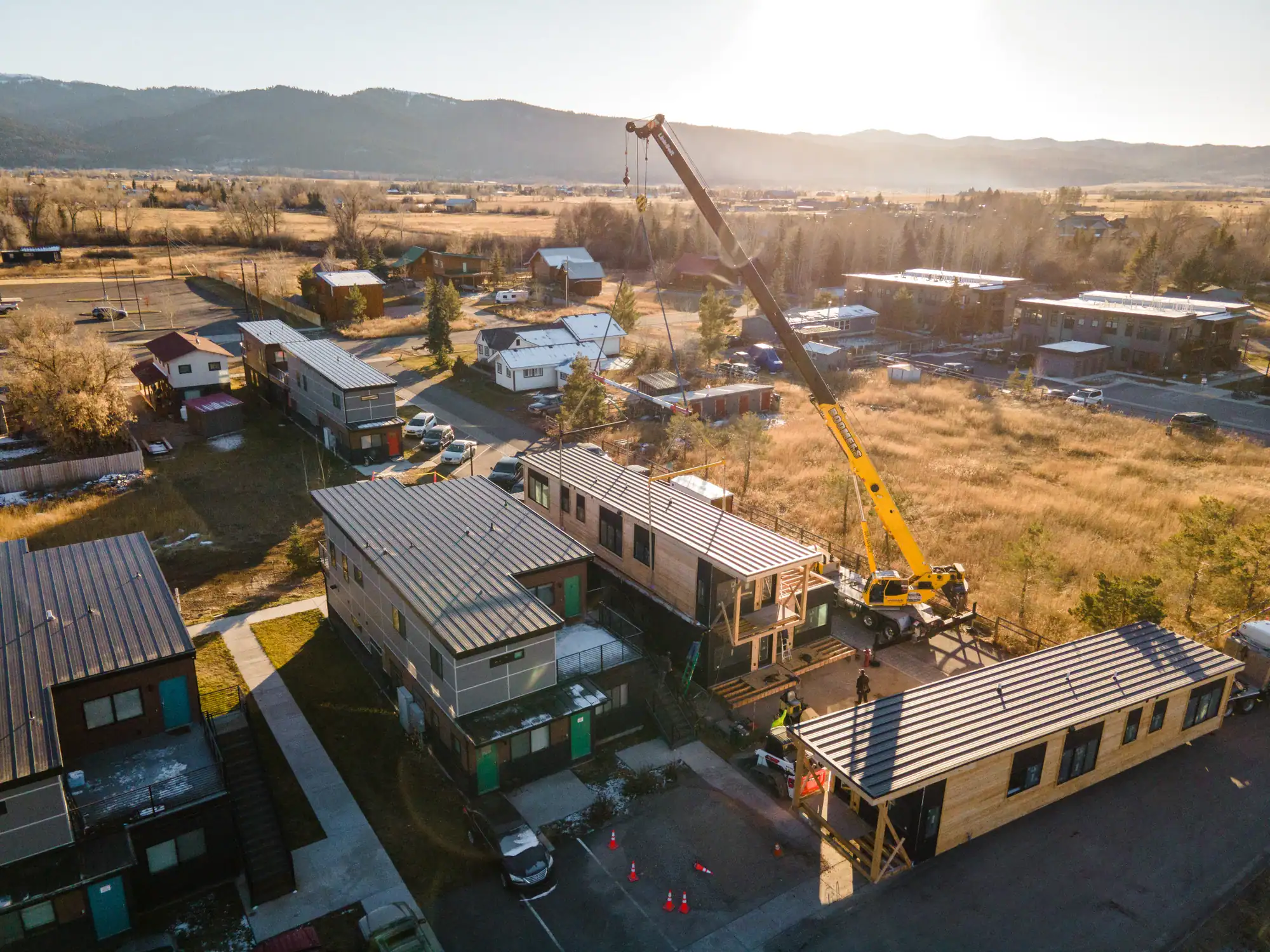 Aerial at low sun of modular buildings and a crane at Westgroup in Victor, Idaho